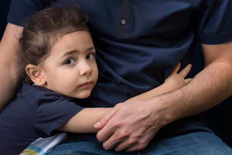 Young girl holding onto her father during a child custody matter in El Paso.