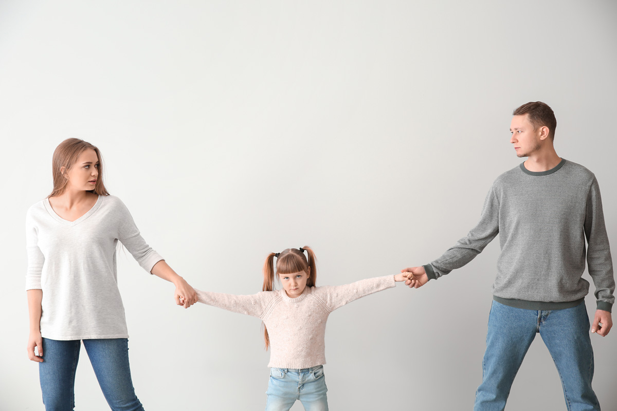 A child holding their parents' hands in El Paso.