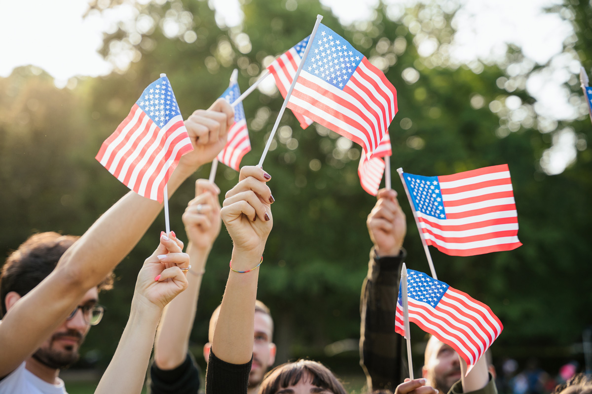People holding up small American flags.