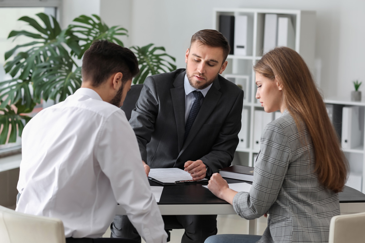 A divorce attorney filing paperwork with a divorced couple in El Paso.