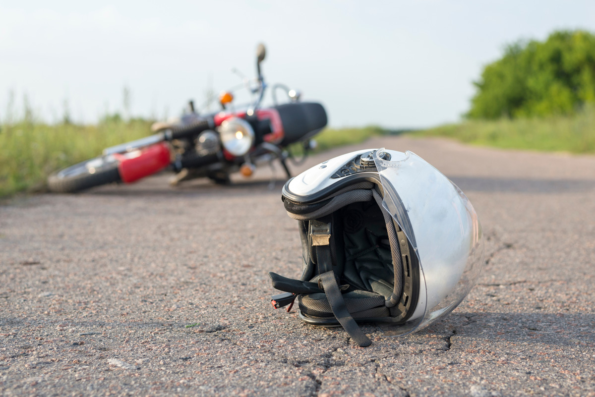A white motorcycle helmet and a red motorcycle lying on a street in El Paso.