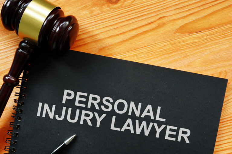 A black notebook that says “PERSONAL INJURY LAWYER” in white with a gavel next to it on a table in El Paso.
